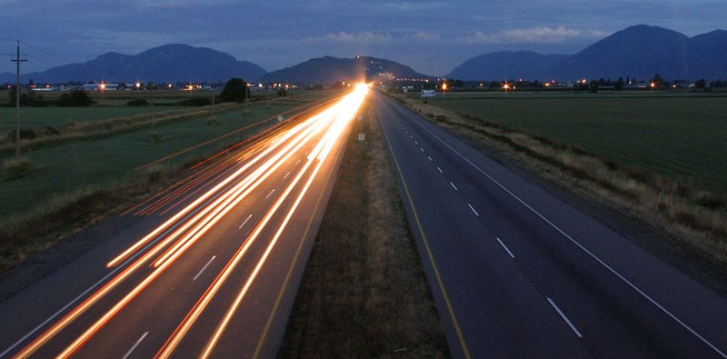 Light trails on the Trans-Canada Highway through farmland in Chilliwack at dawn